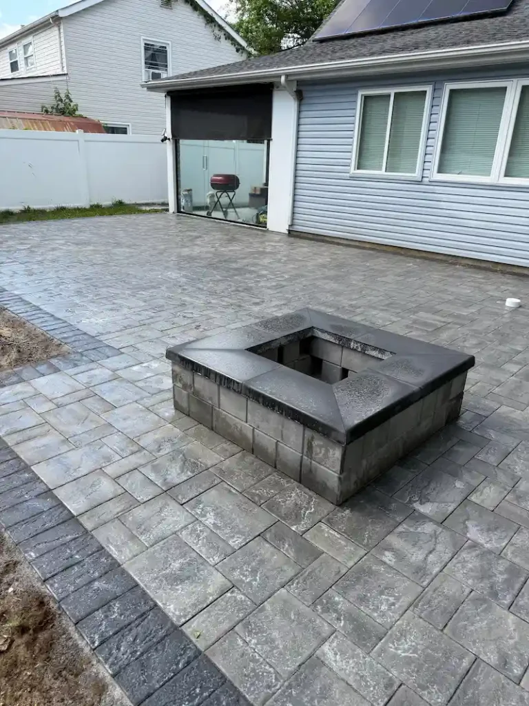 Exterior masonry patio with gray pavers and a built-in fire pit