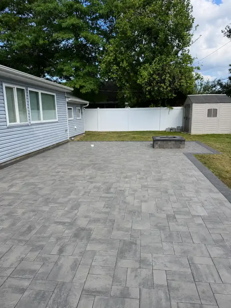 Masonry hardscape patio with gray pavers, dark border, and fire pit